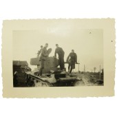 Foto van Duitse soldaten poserend op een verlaten Sovjet T-26 tank
